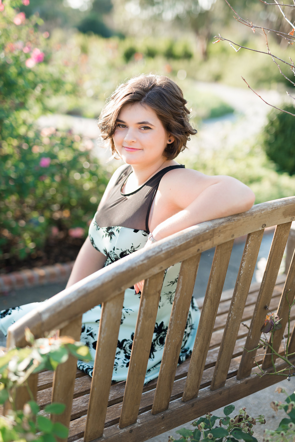 Senior Photographers on Oahu | senior girl sitting on bench with roses in background