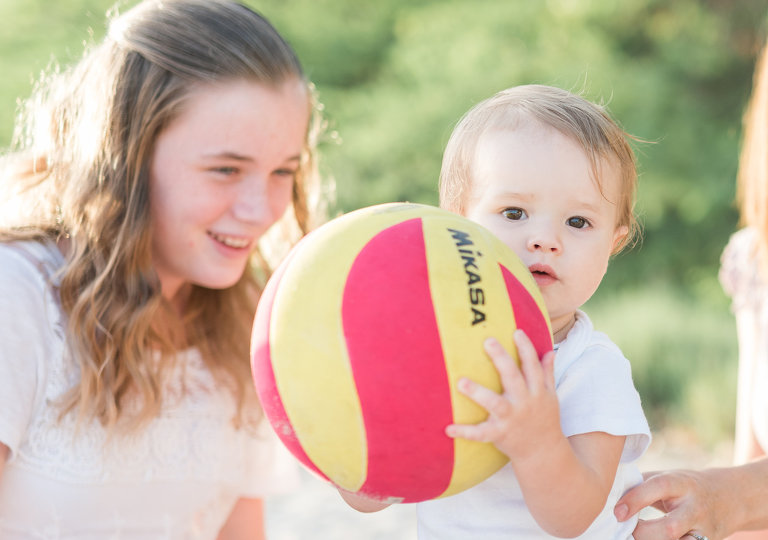 Oahu Family Photographer | Best Honolulu Photographer | Baby girl holding ball on beach with big sister