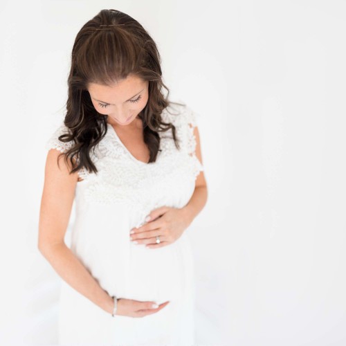Best Oahu Maternity Photographer | Pregnant woman in white dress holding belly
