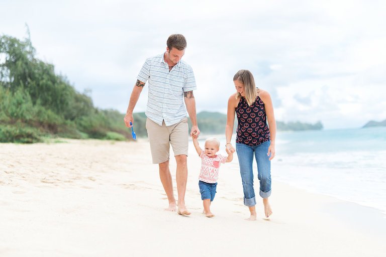 Best family photographer on Oahu | mom and dad walking on beach with toddler