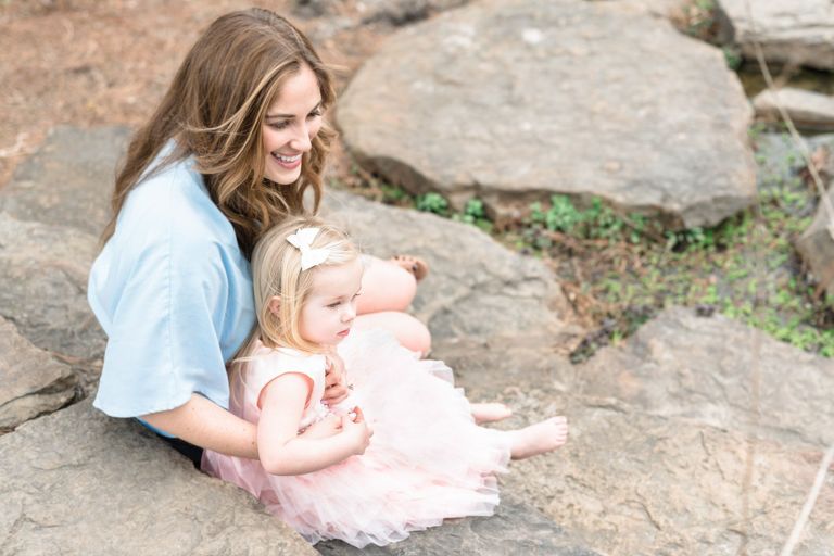 Best Oahu Family Photographers | Celebrate Motherhood Mommy and Me Photo Session | mom holding toddler daughter while sitting on a rock in the park
