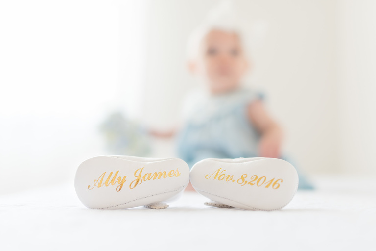 Oahu Baby Photographer | Honolulu Family Photographer | baby booties with name and birthday engraved on bottom with baby girl in background